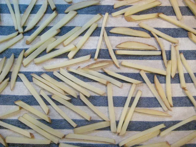 cut potatoes drying on a towel