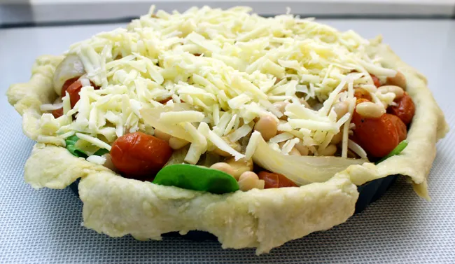 savory tart filled with white beans, spinach, tomatoes and onions, and cheese